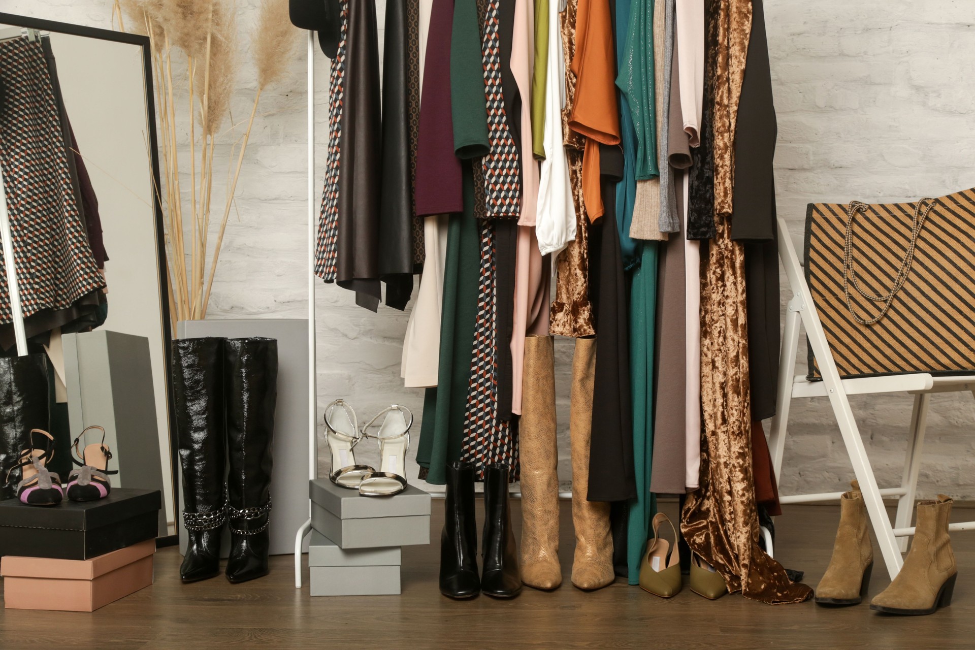 Women's clothes and shoes. Clothes rack with stylish and elegant garments in fashion atelier. Good quality timeless fashion pieces.